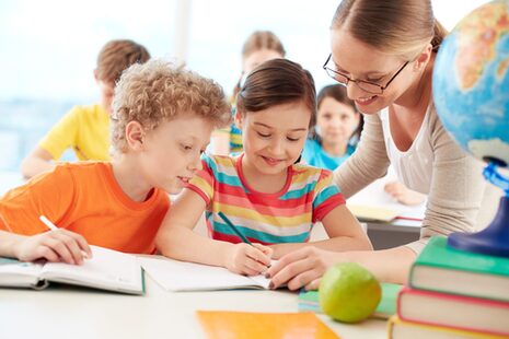Une enseignante explique une tâche à des élèves de primaire